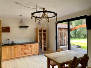 a kitchen with a table and a dining room at Apartamenty przy Młynie in Chyżne