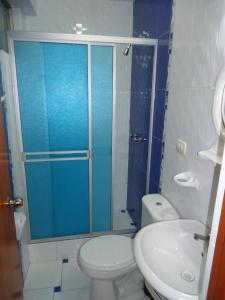 y baño con ducha, aseo y lavamanos. en Hostal Puerto Ingles, en Ilo