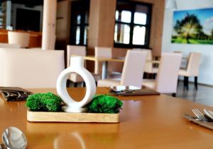 a wooden table with a statue of an open symbol on it at Hotel Žabčice in Žabčice