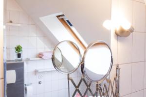 een badkamer met een spiegel aan de muur bij Haus Tjalk Ferienhaus Tjalk rechts in Norddeich