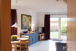 uma sala de estar com uma mesa de jantar e uma televisão em Haus Tjalk Ferienhaus Tjalk links em Norddeich