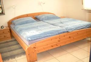 uma cama de madeira com uma estrutura de madeira num quarto em Ferienhaus Albatros em Norddeich