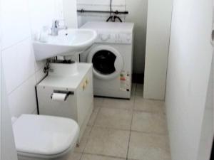 uma casa de banho com uma máquina de lavar roupa e um lavatório em Ferienhaus Albatros em Norddeich