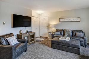 a living room with two couches and a flat screen tv at Anchorage Retreat Less Than 5 Mi to Hilltop Ski Area! in Anchorage