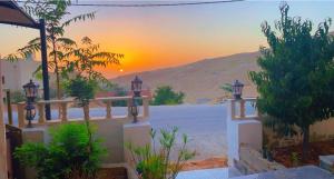 een uitzicht op de zonsondergang vanuit een villa bij Petra Rose Apartment in Wadi Musa