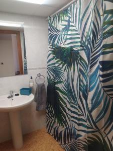 baño con lavabo y papel pintado de palma en Apartamento en Puerto de Mazarrón, en Puerto de Mazarrón