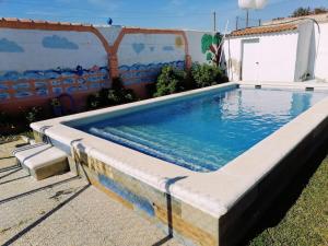 uma grande piscina com um colchão em frente a um edifício em Chiclana El Principito em Chiclana de la Frontera
