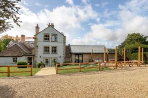 a house with a wooden fence in front of it at Historic country house retreat with indoor swimming pool and hot tub, ideal for large groups in Petty France