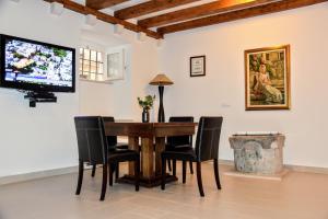 een eetkamer met een tafel en stoelen en een tv bij Celenga Apartments with free offsite parking in Dubrovnik