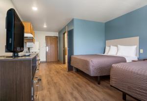 a hotel room with two beds and a flat screen tv at Extended Stay America Select Suites - Fort Myers in Fort Myers