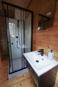 a bathroom with a white sink and a shower at Sea Zone Domek całoroczny przy plaży in Dębki