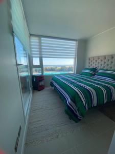 1 dormitorio con cama y ventana grande en Departamento full equipado - con laguna artificial lo mejor del litoral, en Las Cruces