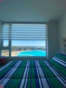 1 dormitorio con cama y ventana grande en Departamento full equipado - con laguna artificial lo mejor del litoral, en Las Cruces