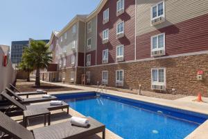 a swimming pool in front of a building at Extended Suites Mexicali Catavina in Mexicali