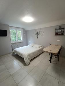 Schlafzimmer mit einem Bett und einem Holztisch in der Unterkunft studio 2 personnes entre campagne et plages in Questembert