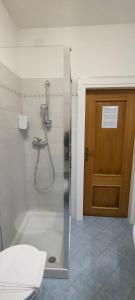 La salle de bains est pourvue d'une douche avec une porte en verre. dans l'établissement Bed & Bar Mini Apartment, à Pontebba