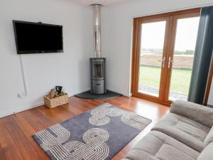 a living room with a couch and a flat screen tv at Ucheldir in Llanfyrnach