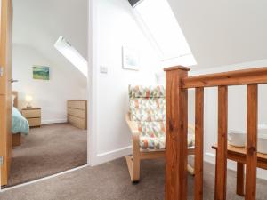 a living room with a staircase and a chair at Atlantic Reach in Marazion