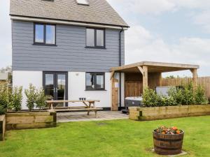 a detached house with a patio and a picnic table at Atlantic Reach in Marazion