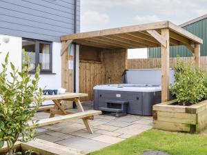 a hot tub and a picnic table in a backyard at Atlantic Reach in Marazion