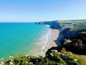 a view of the beach from the cliffs at Tregurrian Villas in Newquay