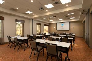 a conference room with tables and chairs and a screen at Hyatt House San Juan in San Juan