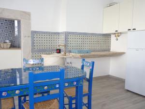 eine Küche mit zwei blauen Stühlen und einem Tisch in der Unterkunft Páteo dos Oliveira - Casa dos Senhores in Évora