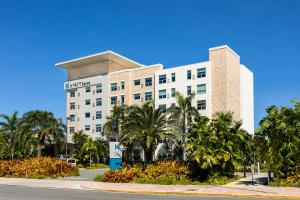 um hotel com palmeiras em frente a um edifício em Hyatt House San Juan em San Juan