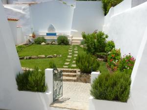 Páteo dos Oliveira - Casa dos Senhores في ايفورا: حديقة بجدران بيضاء ودرج