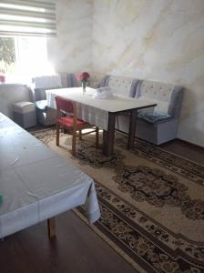 a living room with a table and a couch at "Kamchybek Ata" guest house B&B in Tërt-Kul'