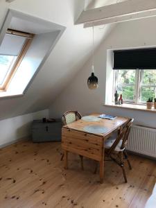 a dining room with a wooden table and two chairs at Istrup gammel skole in Bedsted Thy +12 photos