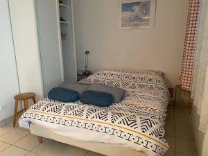 uma cama com duas almofadas num quarto em Studio Option face à la mer em Agon Coutainville