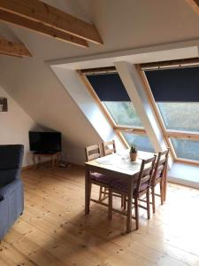 een eetkamer met een tafel, stoelen en ramen bij Istrup gammel skole in Bedsted Thy