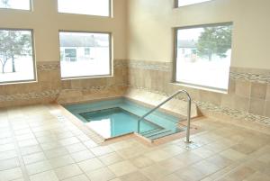 a swimming pool in a room with two windows at C'Mon Inn in Thief River Falls