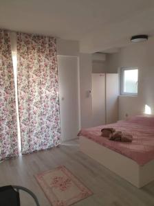 1 dormitorio con 1 cama con cortinas rosas y ventana en Cavleski rooms, en Prilep