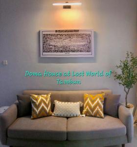 un sofá en una sala de estar con una foto en la pared en Doma House Alpine at Lost World of Tambun, en Tambun