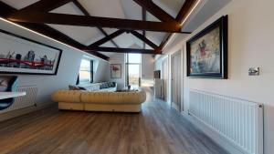 uma sala de estar com um sofá num quarto com pisos em madeira em Barbican Boutique Luxury Apartments & Rooms, Plymouth em Plymouth