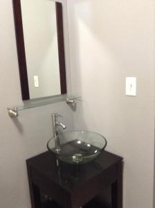 a bathroom with a glass sink and a mirror at Villa Ensenada Honda in Culebra