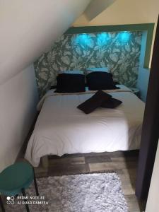a bedroom with a white bed with blue lights on it at Maisonnette en bord de rivière tout près du Mans in La Bazoge