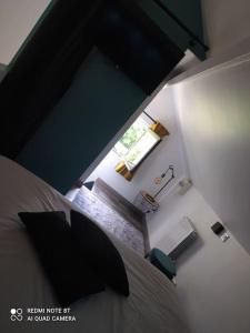 a bedroom with a bed and a room with a window at Maisonnette en bord de rivière tout près du Mans in La Bazoge