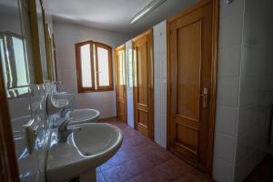 a bathroom with two sinks and two mirrors at Albergue del serpis in Lorcha