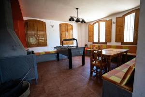 una cocina con armarios de madera, mesa y sillas en Albergue del serpis, en L'Orxa (Lorcha)