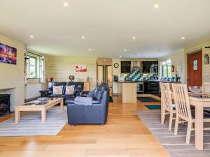 uma sala de estar com um sofá e uma mesa em Primrose Lodge em Holsworthy