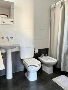 a bathroom with a white toilet and a sink at Departamento tranquilo completamente equipado in Salta