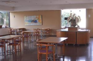 una sala da pranzo con tavoli e sgabelli di Tuti Bororô a Rondonópolis