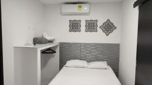 a small room with a bed and a wall at Apartamentos Las Piloneras in Valledupar