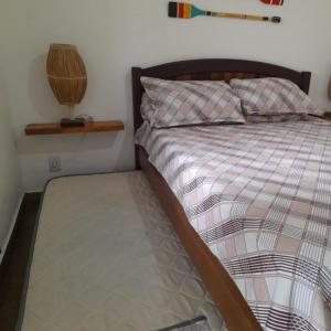 a bedroom with a bed with a wooden head board at temporada praia do forte cabo frio in Cabo Frio