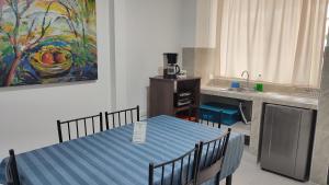 a kitchen with a table and a painting on the wall at Apartamentos Las Piloneras in Valledupar