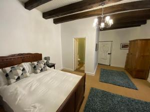 a bedroom with a large white bed and a chandelier at Maison Dix Tusson in Tusson