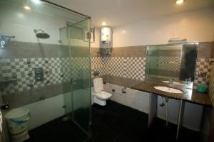 a bathroom with a shower and a toilet and a sink at Kartikay hotel in Hisār